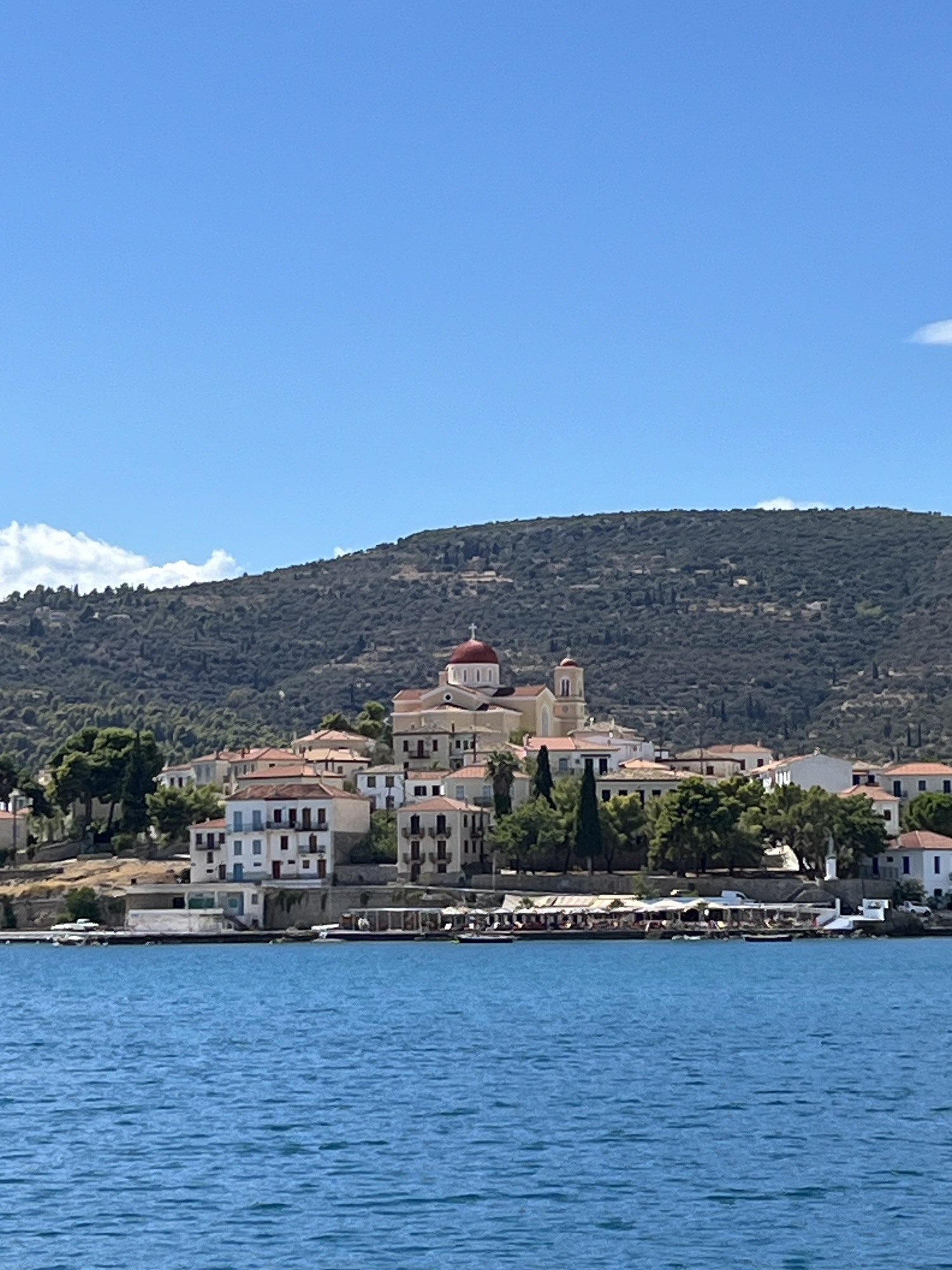 View of beautiful historic town on hill over water in Gulf of Corinth, Greece